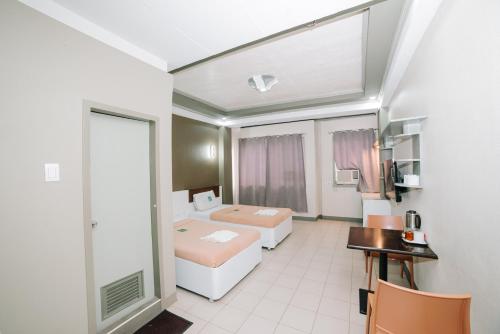 Pokój hotelowy z 2 łóżkami i biurkiem w obiekcie GC Hotel w mieście Zamboanga
