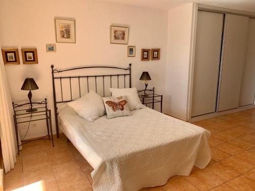 アデへにある2 Bedroom Townhouse In Puerto Colonのベッドルーム1室(蝶の枕付きのベッド1台付)