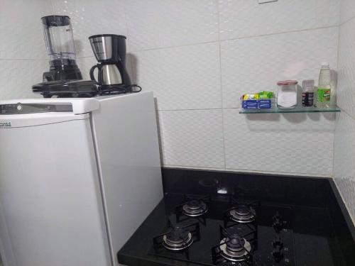 a stove top oven in a kitchen next to a refrigerator at Tambaú Flat, Mar Azul in João Pessoa