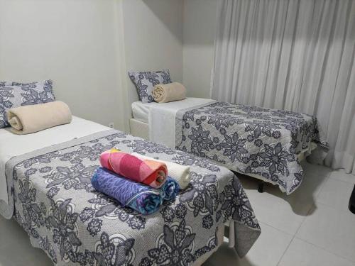 a room with three beds with blankets and pillows at Tambaú Flat, Mar Azul in João Pessoa