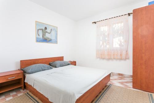 a bedroom with a bed and a window at Apartments by the sea Sevid, Trogir - 4287 in Sevid