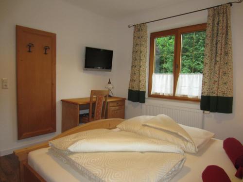 um quarto com uma cama, uma janela e uma secretária em Heidi's Schlummerkiste em Breitenau am Hochlantsch