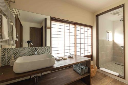 a bathroom with a large tub and a shower at Himecho@Yasushi in Nozawa Onsen