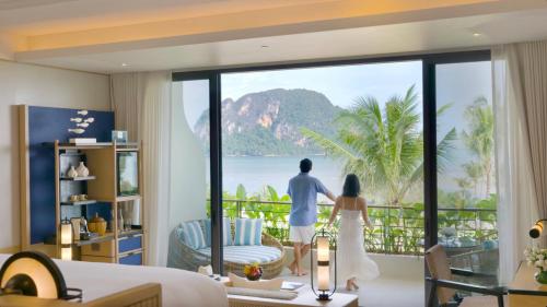 um homem e uma mulher numa sala com vista para o oceano em Anantara Koh Yao Yai Resort & Villas em Ko Yao Yai