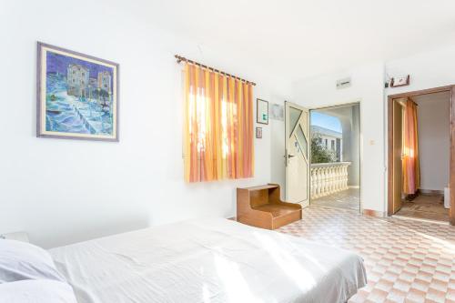 a white bedroom with a bed and a balcony at Apartment Sevid 4287d in Sevid