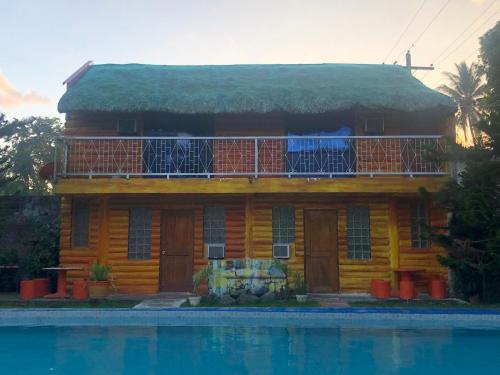 a yellow house with a balcony and a swimming pool at Vi-Da Guest Resort in Irosin