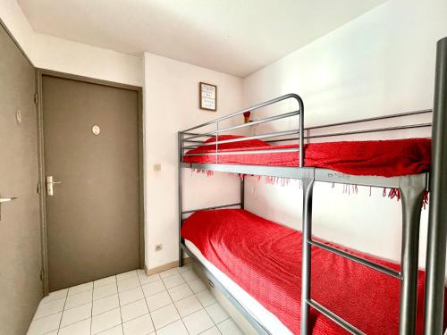 1 dormitorio con 2 literas con sábanas rojas en Appartement Sète, 2 pièces, 6 personnes - FR-1-338-168 en Sète