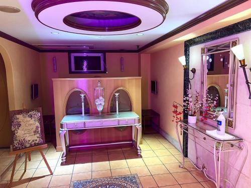 ein Badezimmer mit einem lila Waschbecken und einem Spiegel in der Unterkunft Hotel Pareo (Adult Only) in Kōbe