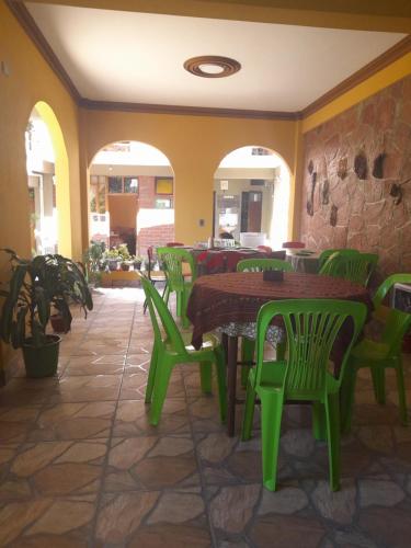 restauracja z zielonymi stołami i zielonymi krzesłami w obiekcie Hospedaje Matita - Torotoro w mieście Torotoro