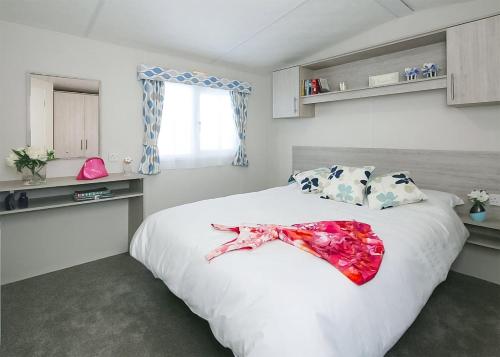 a bedroom with a large white bed with a dress on it at Springhouse Country Park in Slaley
