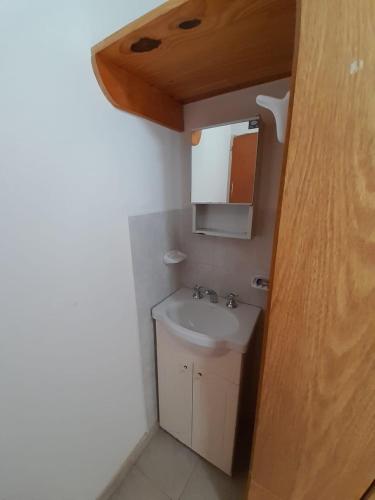 a bathroom with a sink and a mirror at Departamentos Tere in Las Grutas