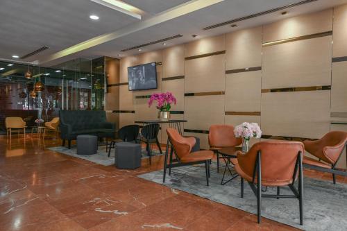 a lobby with chairs and a table with flowers at Hotel Pudu Plaza Kuala Lumpur in Kuala Lumpur