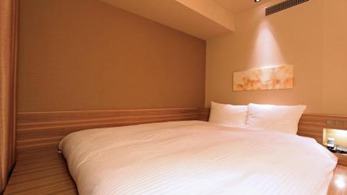 Un ou plusieurs lits dans un hébergement de l'établissement KOKO HOTEL Fukuoka Tenjin