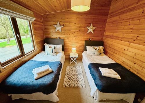 a room with two beds in a log cabin at Pant Wilkin Lodges And Equestrian Centre in Cowbridge
