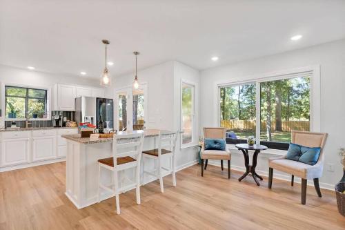 a kitchen with white cabinets and a table and chairs at Middle Sound Hideaway~Beaches, Shopping, Families in Wilmington