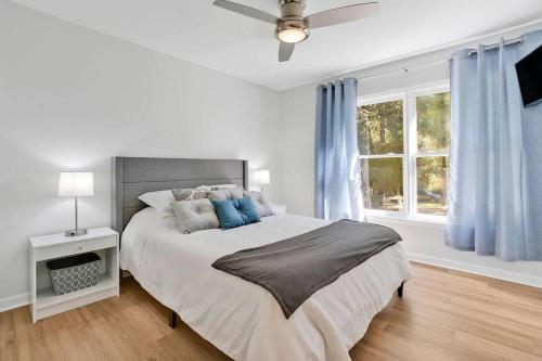 a white bedroom with a large bed with blue pillows at Middle Sound Hideaway~Beaches, Shopping, Families in Wilmington