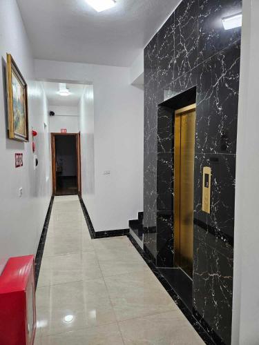 a hallway with a black stone wall and a hallway with a door at Hoàng Gia Hotel Royal in Kim Bảng