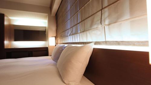 Un ou plusieurs lits dans un hébergement de l'établissement KOKO HOTEL Fukuoka Tenjin