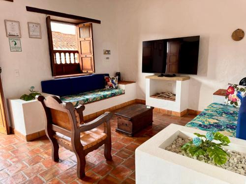 uma sala de estar com um sofá e uma televisão em Casa La Bonita - Barichara em Barichara