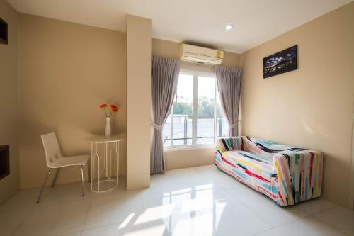 a room with a chair and a table and a window at Khao Rang Place in Phuket Town
