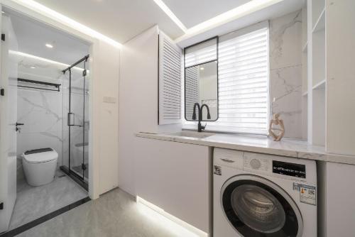 a bathroom with a washing machine and a sink at Molly Homestay - Nanjing East Road the Bund 3-Bedroom with Elevator Apartment in Shanghai