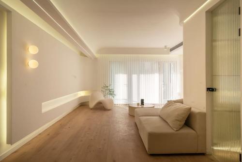 Molly Homestay - Nanjing East Road the Bund 3-Bedroom with Elevator Apartment في شانغهاي: غرفة معيشة مع أريكة ونافذة