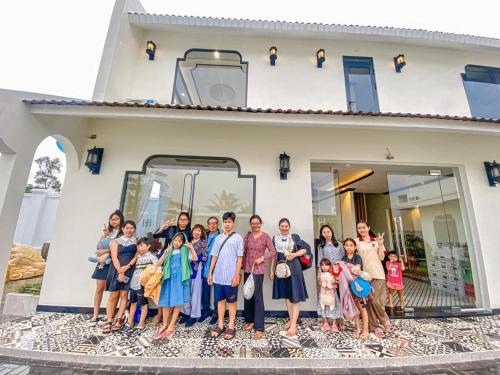 een groep mensen die voor een huis staan bij Khách Sạn The Rice Cái Bè in Cai Be