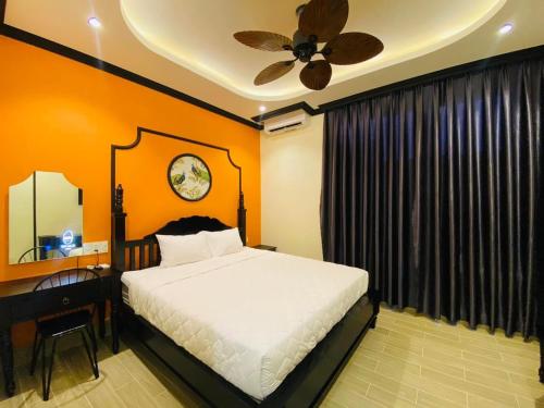 1 dormitorio con cama, escritorio y ventilador de techo en Khách Sạn The Rice Cái Bè en Cai Be