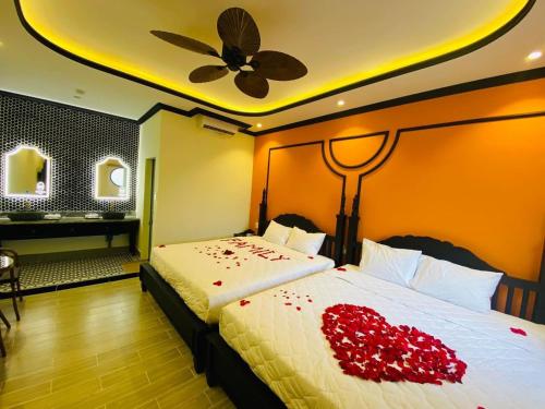 a bedroom with a bed with red roses on it at Khách Sạn The Rice Cái Bè in Cai Be