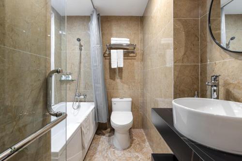 a bathroom with a toilet and a tub and a sink at Nature Hotel in Hanoi