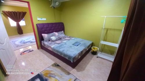 een slaapkamer met een paars bed in een groene kamer bij HOMESTAY TOKMA PASIR MAS in Pasir Mas