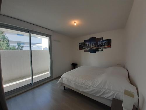 ein Schlafzimmer mit einem Bett und einem großen Fenster in der Unterkunft Appartement Anglet, 2 pièces, 4 personnes - FR-1-239-1021 in Anglet