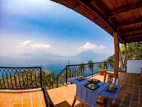 a table on a balcony with a view of the ocean at Casa Laguna: Best View In The World in Santa Cruz La Laguna