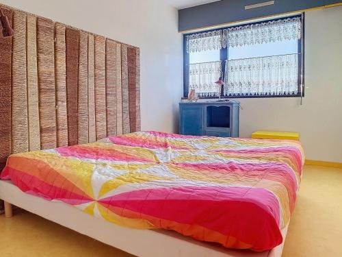 une chambre avec un lit avec une couette colorée dans l'établissement Duplex 8 pers proche mer avec balcon, parking et équipements complets - FR-1-746-17, à Courseulles-sur-Mer