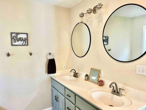 a bathroom with two sinks and a large mirror at Renovated home 10 min from FLW! in Saint Robert