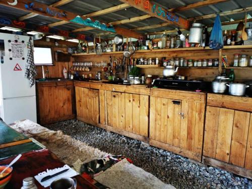 a kitchen with wooden cabinets and a refrigerator at Yurt camp Besh-Karagai in Grigor'yevka