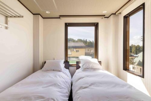 Address Nagasaka في نوزاوا أونسن: سريرين في غرفة صغيرة مع نافذة