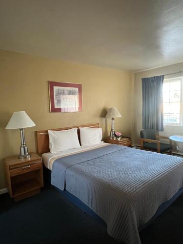 a hotel room with a large bed and two lamps at Marco Polo Motel in Seattle