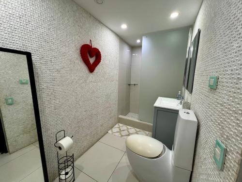 a bathroom with a toilet and a heart on the wall at Condado Lux Oceanfront Tantra Ap in San Juan