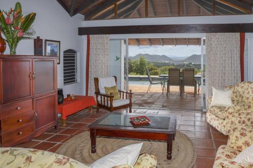 sala de estar con sofá y mesa de centro en Spanish-style Ocean view Villa set in garden - Calypso Court villa, en Cap Estate