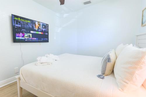 a bedroom with a bed with a tv on the wall at Snook Haven - Hot Tub, Pool, Minigolf, Dog Space in Largo