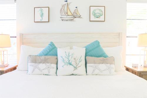 a bedroom with a bed with blue and white pillows at Snook Haven - Hot Tub, Pool, Minigolf, Dog Space in Largo