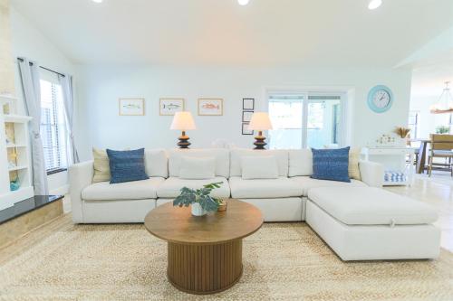 a living room with a white couch and a table at Snook Haven - Hot Tub, Pool, Minigolf, Dog Space in Largo