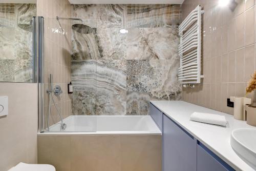 W łazience znajduje się wanna i umywalka. w obiekcie Doki Studio Superior by Grand Apartments w Gdańsku