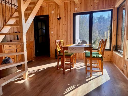 a dining room with a table and chairs and a staircase at Aproka - Chalet Mignon Adorable small guest house in Sicasău