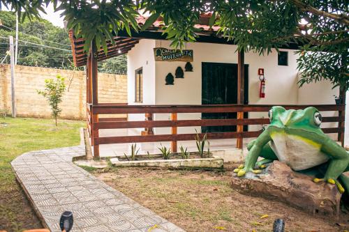 a frog sitting on a rock in front of a house at Pousada e Restaurante Amazonia in Alter do Chao