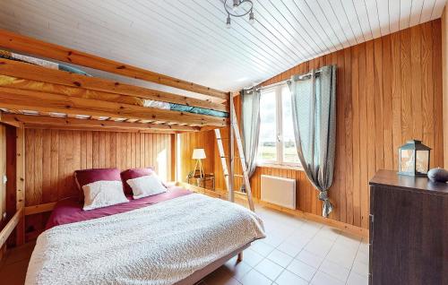 ein Schlafzimmer mit einem Bett in einem Holzzimmer in der Unterkunft Nice Home In La Bazouge-de-chemer With Kitchen in La Cropte