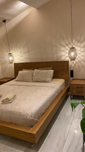 a bedroom with a wooden bed with two lamps at Sea-side Mountain Villa in Iraklitsa