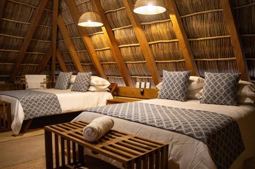 2 camas en una habitación con techos de madera en Villa Tanatli, en Pérula