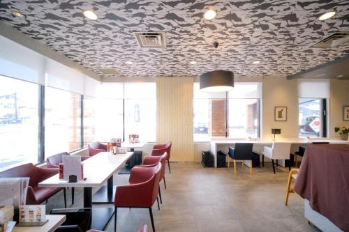 a restaurant with a patterned ceiling with tables and chairs at Yuzawa Royal hotel in Yuzawa